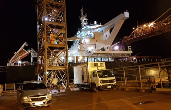 Night delivery of ship stores to a vessel under crane at a Brazilian port