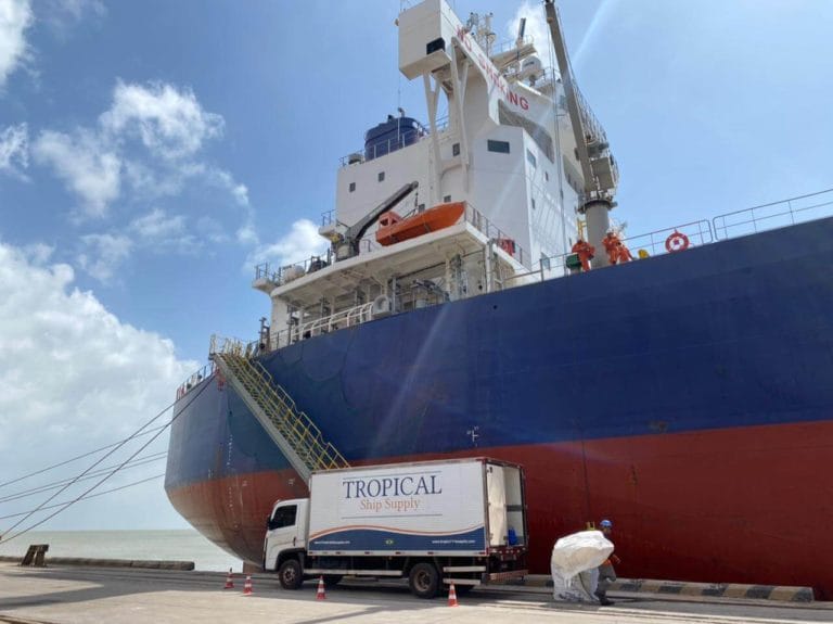 Tropical Ship Supply truck alongside the bow of a bulk carrier at the berth