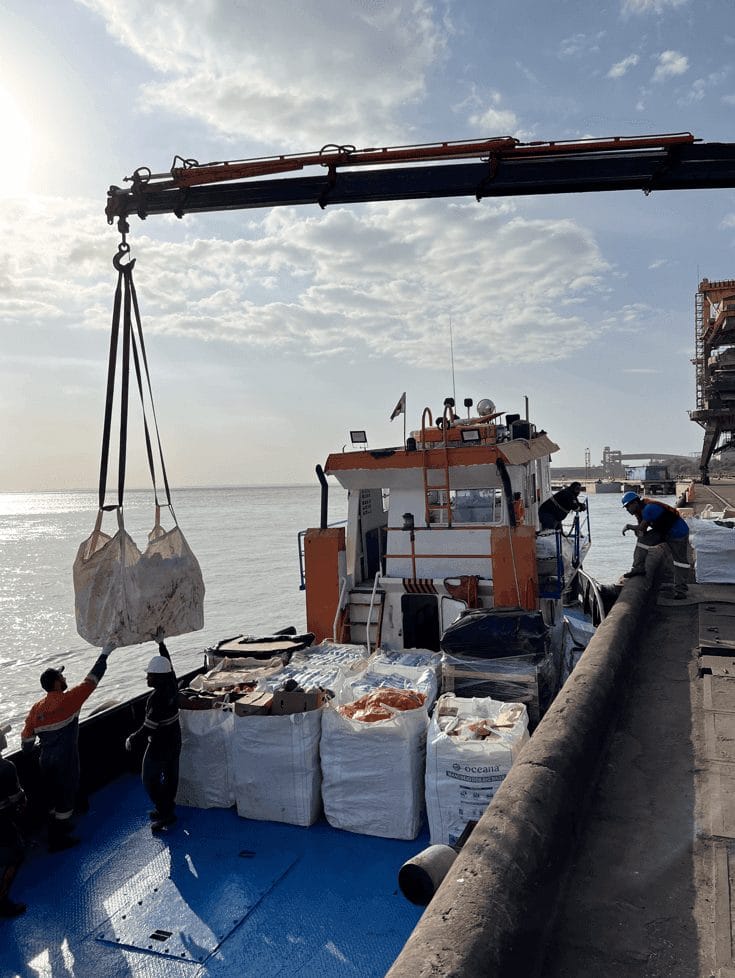 Crane lifting bulk bags to a supply boat for a vessel at the anchorage