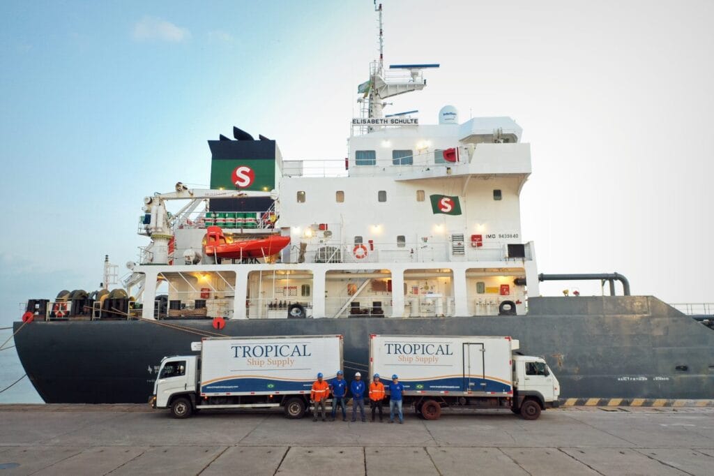 Two Tropical Ship Supply refrigerated trucks alongside a vessel at the berth