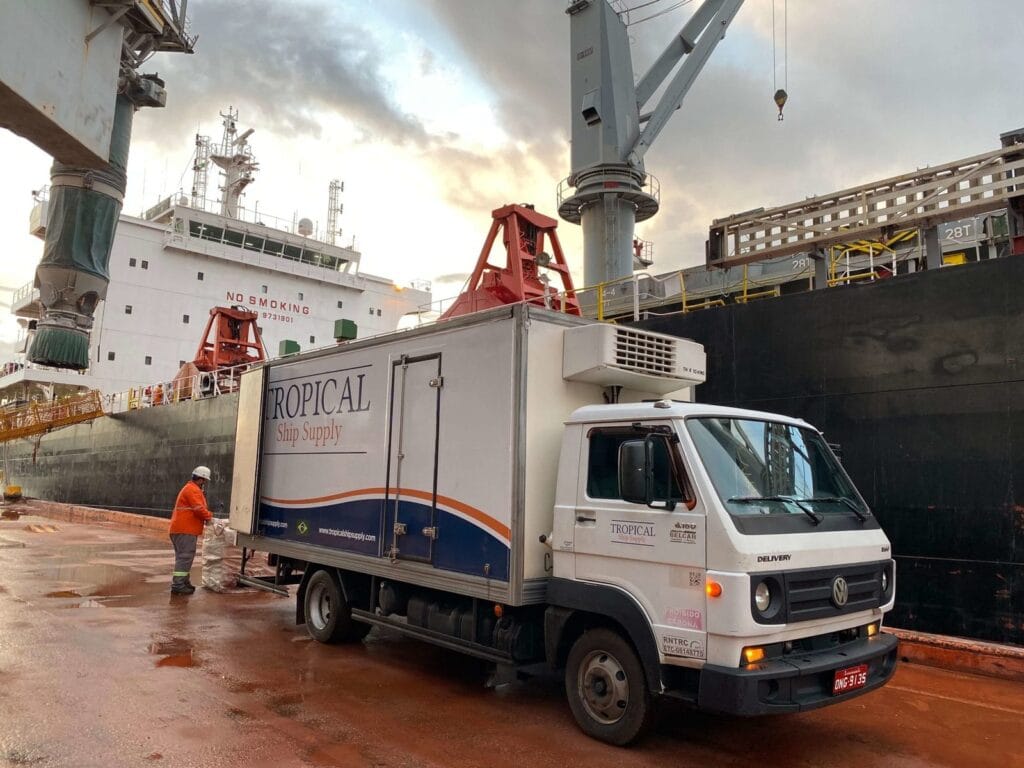 Ship stores delivery alongside a vessel, with crew assisting at the quayside