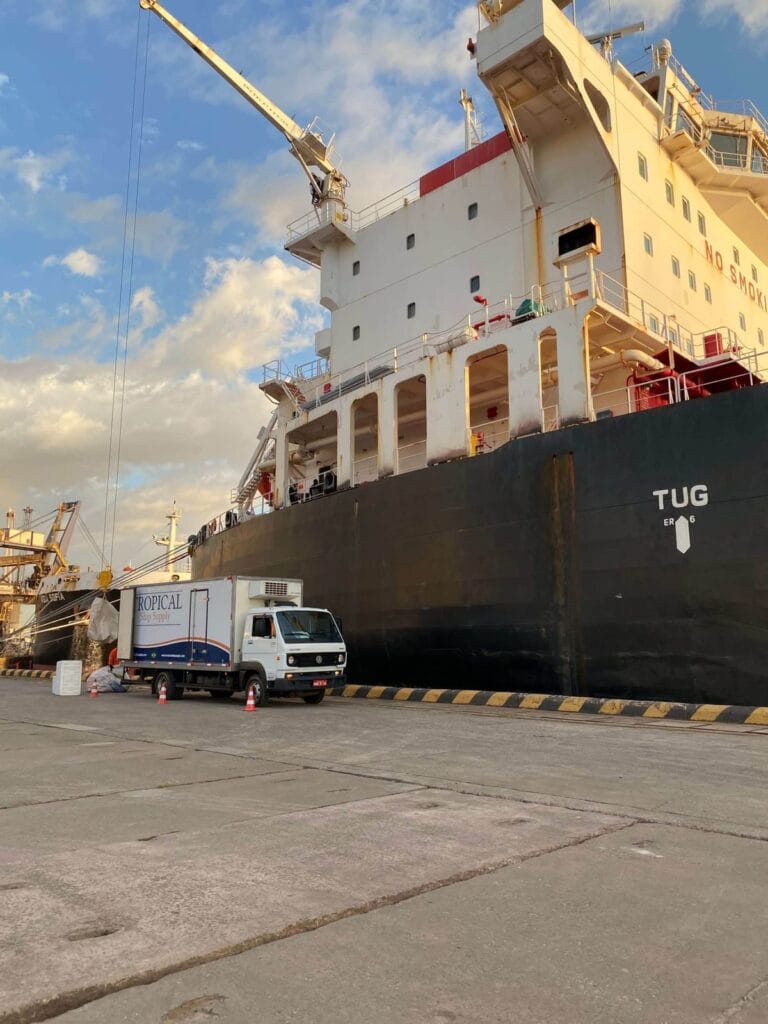 Tropical Ship Supply truck alongside a tug at the berth