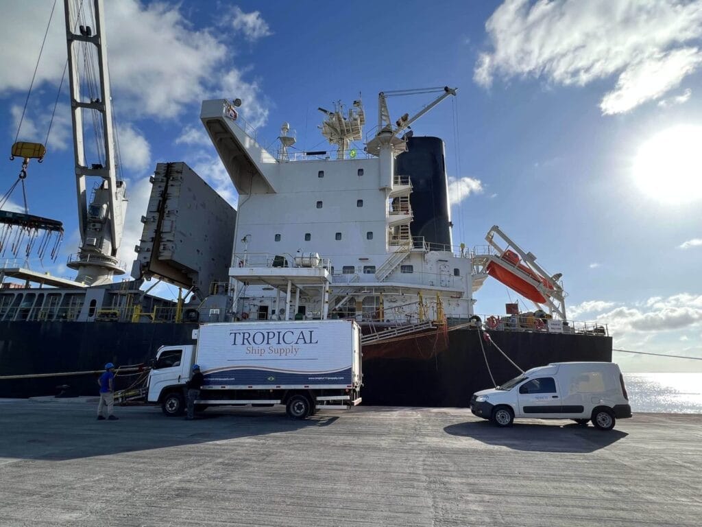 Tropical Ship Supply truck and van alongside a general cargo vessel at the berth