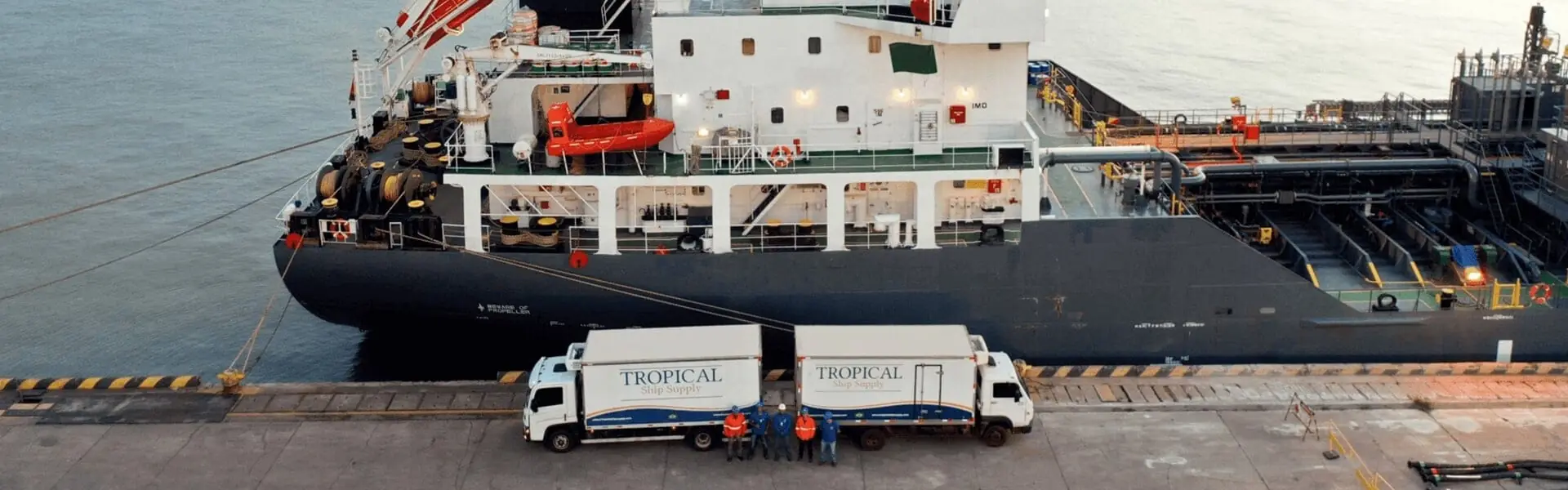 Tropical Ship Supply refrigerated trucks and crew alongside a vessel in a Brazilian port